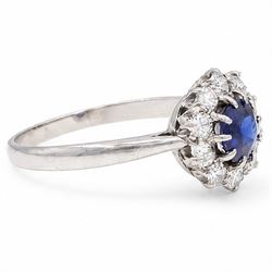 Platinum sapphire and diamond cluster ring, single round cut sapphire of approx 0.85 carat, surrounded by ten round cut diamonds, total diamond weight approx 0.40 carat