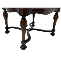 Figured mahogany coffee table, shaped moulded top with oval book-matched veneered panels, on turned supports united by waved X-shaped stretchers 