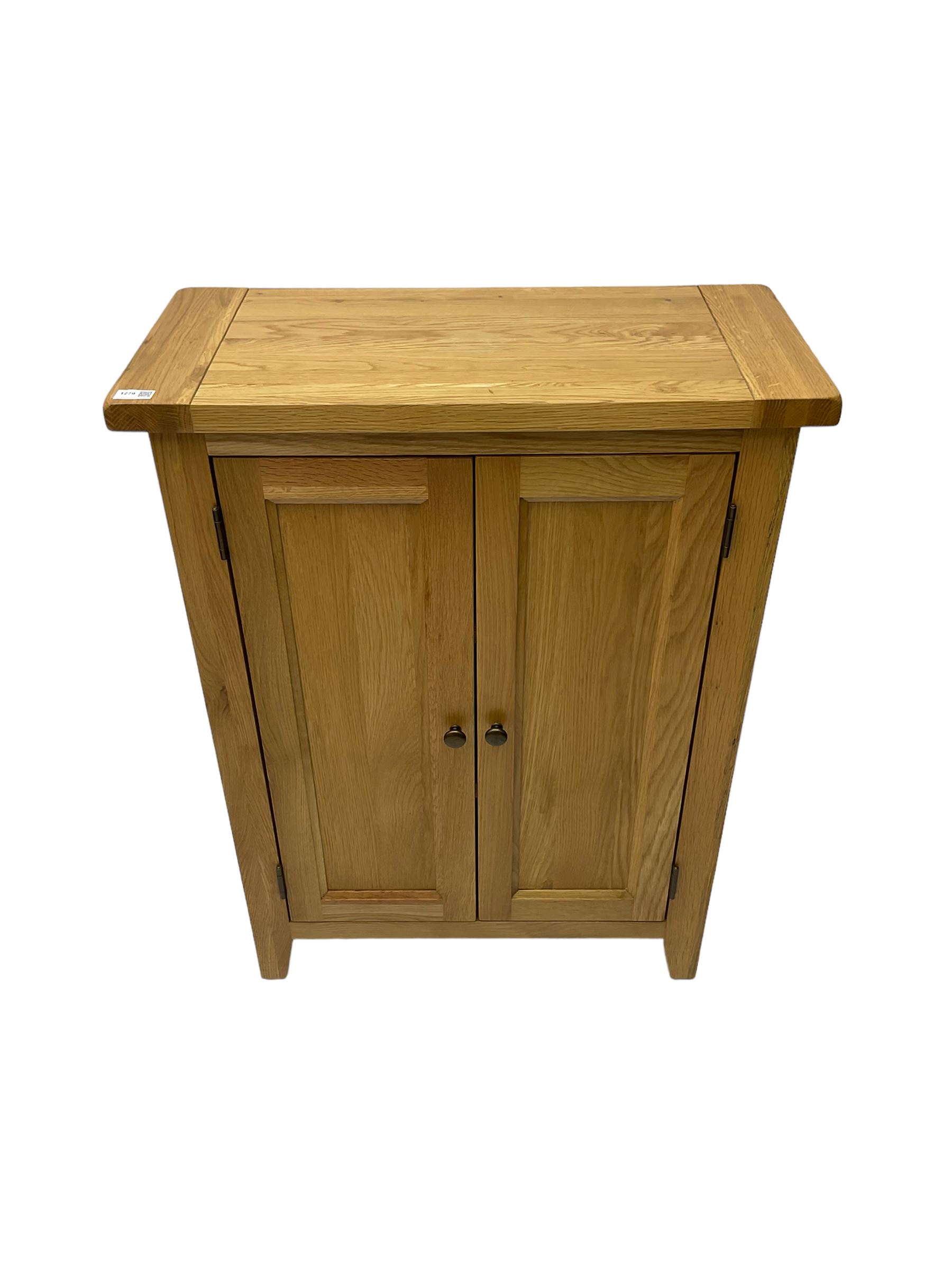 Solid light oak cupboard, fitted with two panelled doors enclosing two shelves, on tapered feet