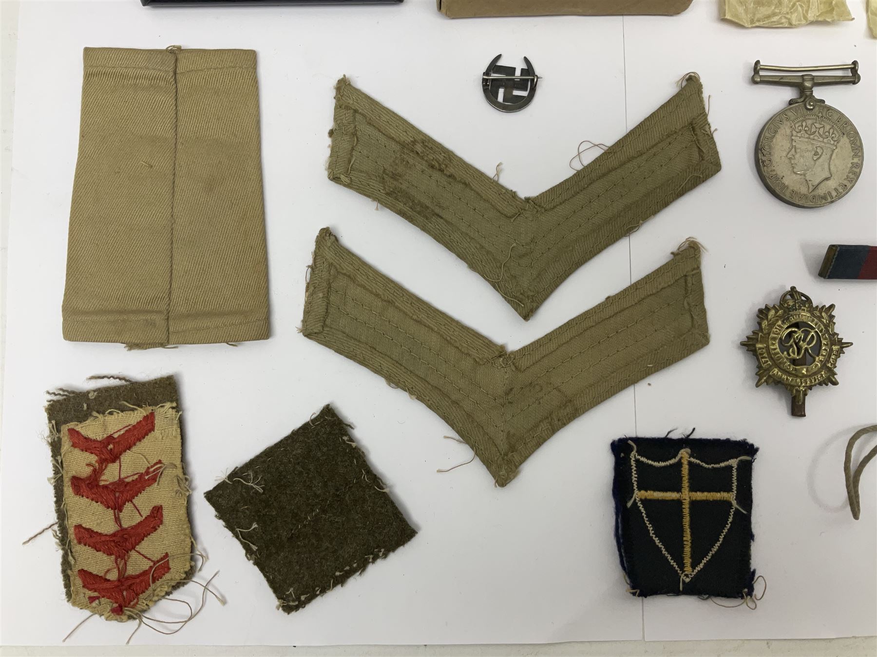 WWII group of three medals comprising 1939-45 War Medal and Italy and Africa Stars in issue box; dog tags for 282894 W. Wilkinson with framed photograph in uniform; and small quantity of cloth and metal badges including RAOC cap badge