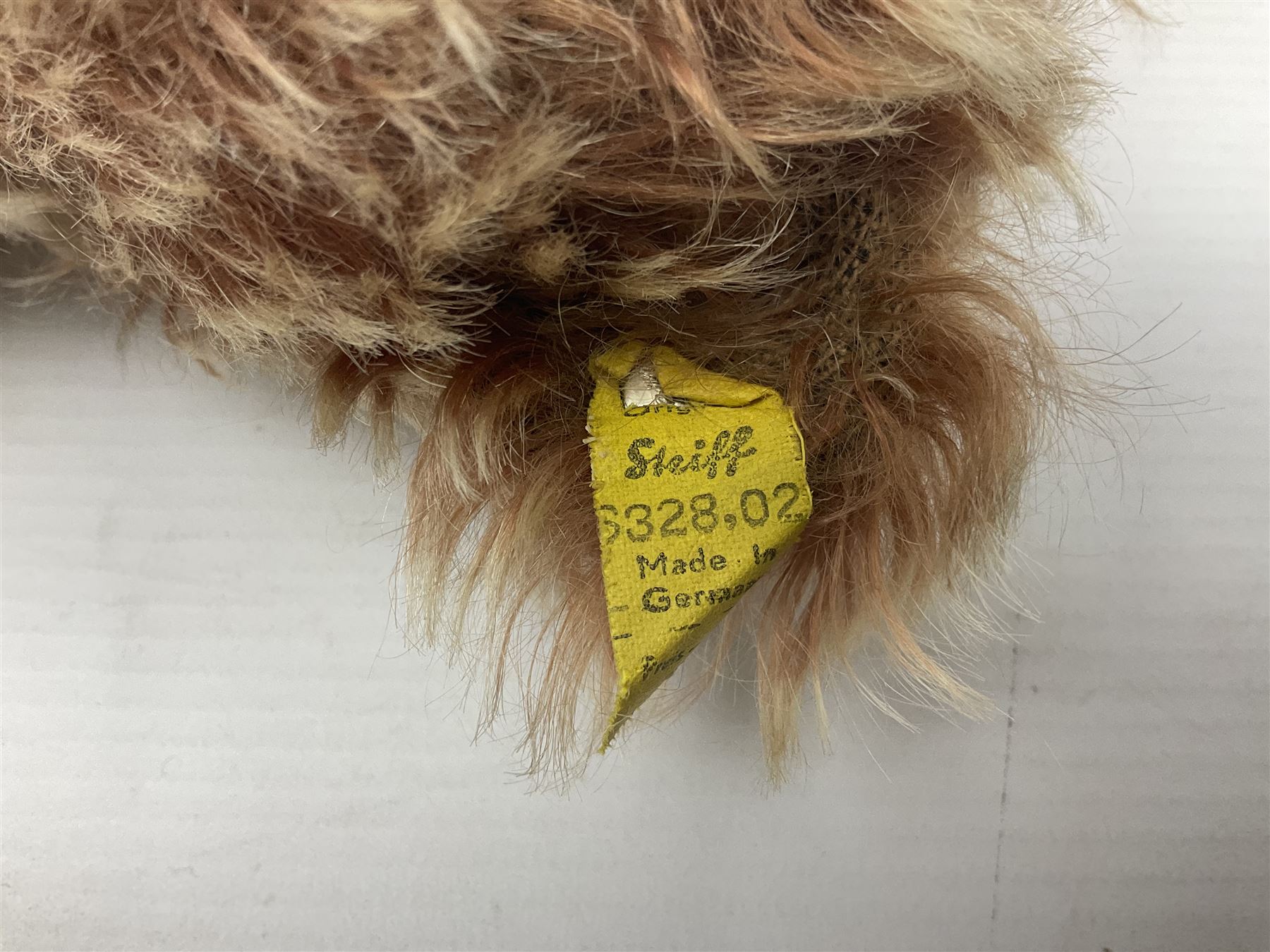 Steiff teddy bear with golden plush body, revolving head, applied eyes, vertically stitched nose and mouth and jointed limbs; button to left ear H26cm; and two other Steiff teddy bears, each with open mouth and button with tag to left ear (3)
