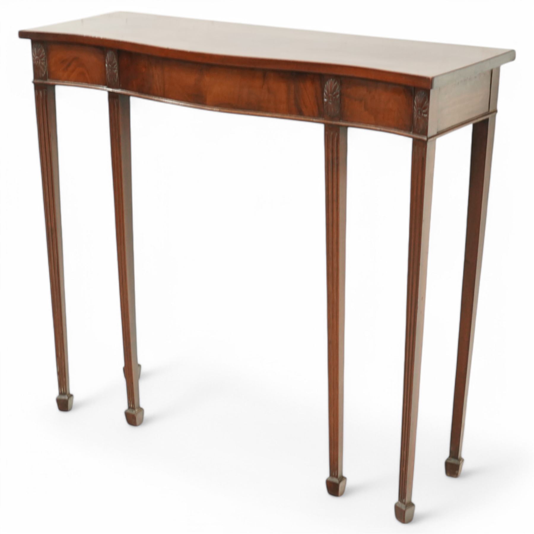 Edwardian mahogany serpentine side table or console table, figured frieze decorated with applied carvings, on six square tapering supports with spade feet
