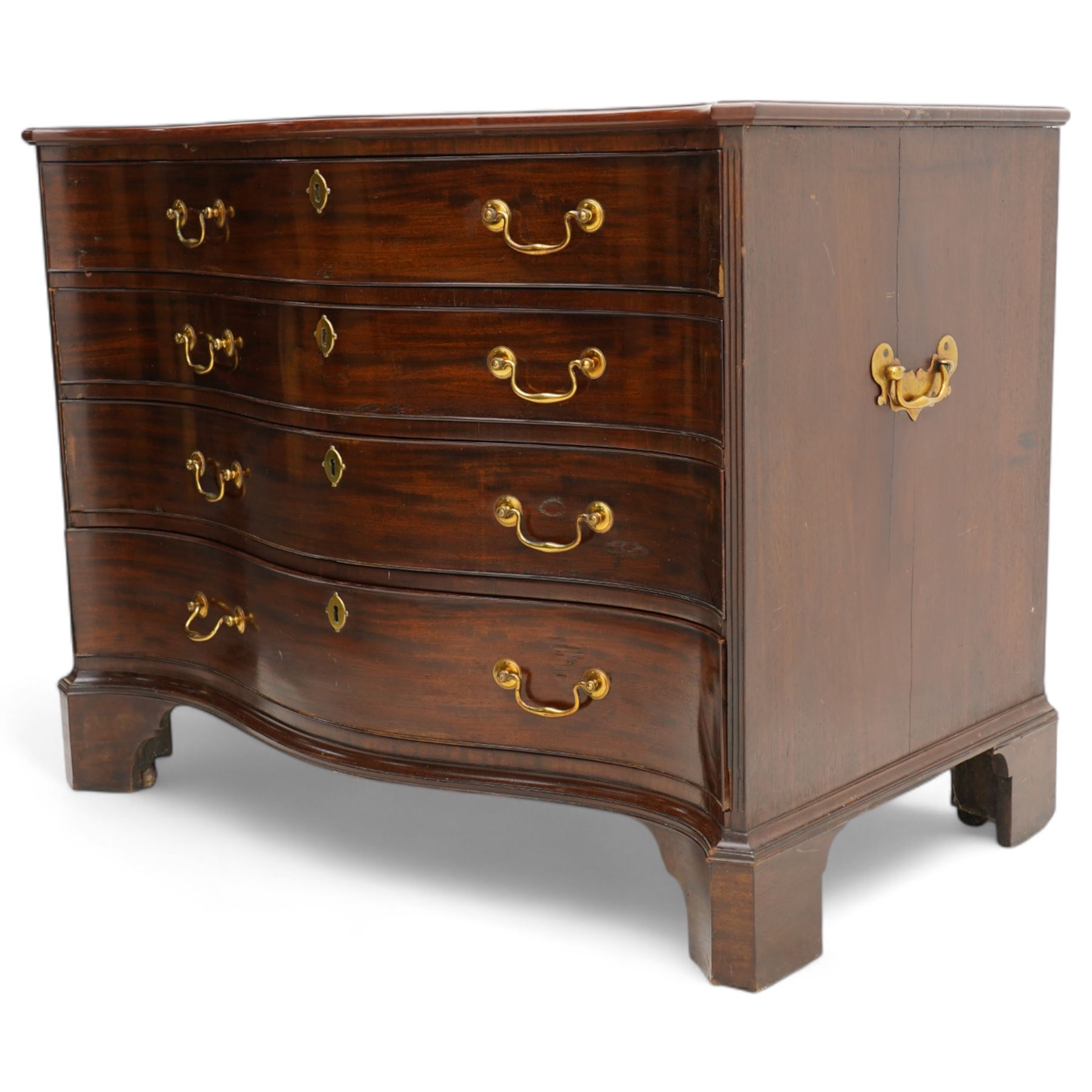 George III mahogany serpentine chest, moulded top over four cock-beaded drawers, the top drawer fitted with baize lined slide opening to reveal divisions,  enclosed by canted and fluted upright corners, the drawer fronts fitted with brass swan neck handles and circular plates with oval escutcheons, lower moulded edge over bracket feet, on lignum vitae castors