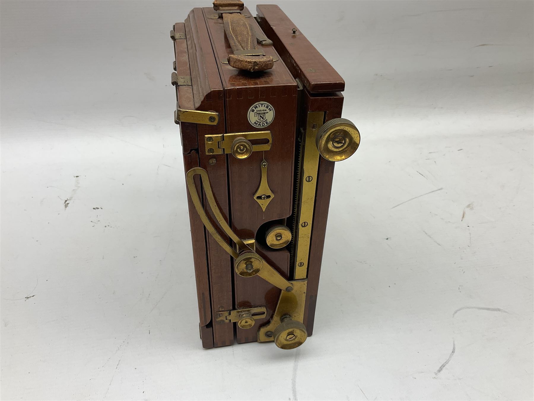Ensign 'The Sanderson' folding plate camera in mahogany and lacquered brass, field model with canvas wrapped box, two mahogany photographic plates, 'Busch rapid Symmetrical F:8' lens,  and a wooden tripod 