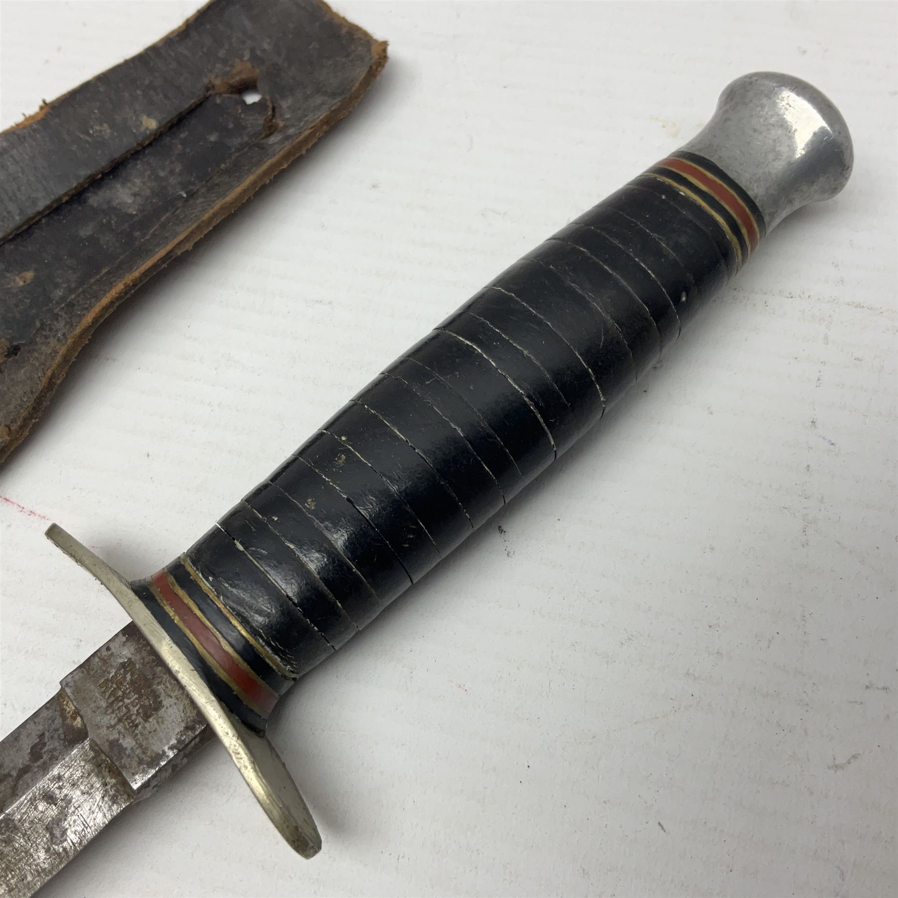  British Private Purchase fighting knife by William Rodgers, Sheffield, the 15cm double edge steel blade with raised medial ridge, stamped on one side of the ricasso WILLIAM RODGERS I CUT MY WAY, the opposing side marked MADE IN SHEFFIELD, ENGLAND, with aluminium crossguard and pommel, stacked leather washers grip and leather scabbard L27.5cm overall; and a crudely made short sword with 32.5cm single edged blade and steel knucklebow hilt with hardwood grip; in cane bound wooden scabbard L45cm overall (2)