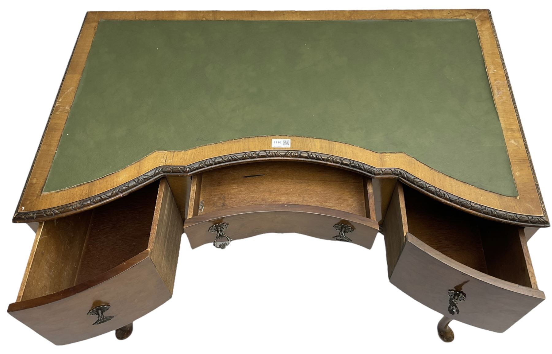 Early 20th century Queen Anne design walnut writing desk, reverse bow-front with inset green leather writing surface and foliate carved edge, fitted with three drawers, raised on cabriole supports