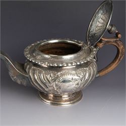 Victorian silver four piece tea service, comprising hot water pot, teapot, milk jug and sugar bowl, of circular part fluted bellied form, with embossed and engraved floral decoration, engraved with initials to body, the teapot and hot water pot with wooden handles and finials, hallmarked Z Barraclough & Sons, Sheffield 1898