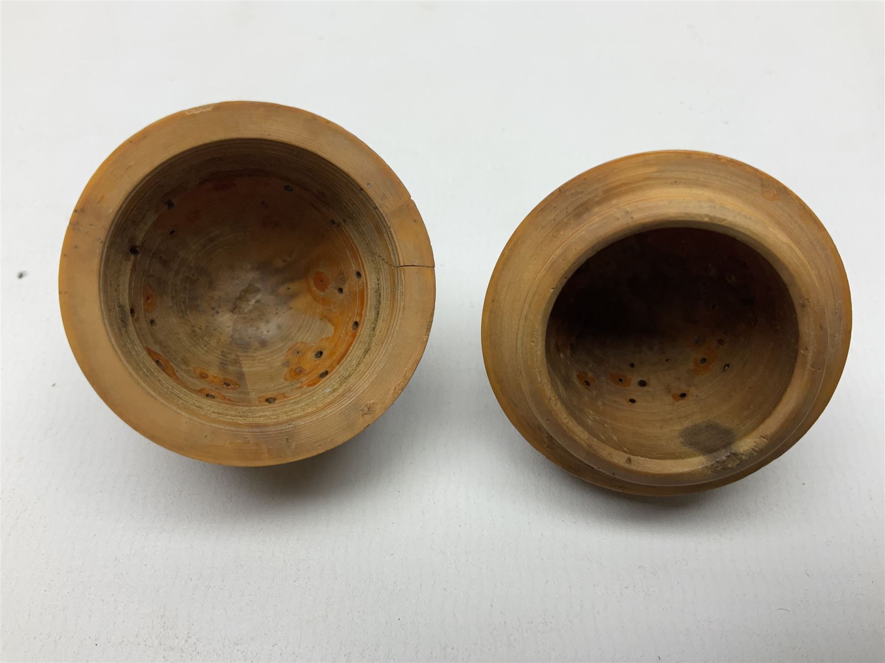 Three 19th century coquilla nut pomanders or flea catchers, each of egg shaped form with carved and pierced decoration and screw threaded join, largest example 6cm