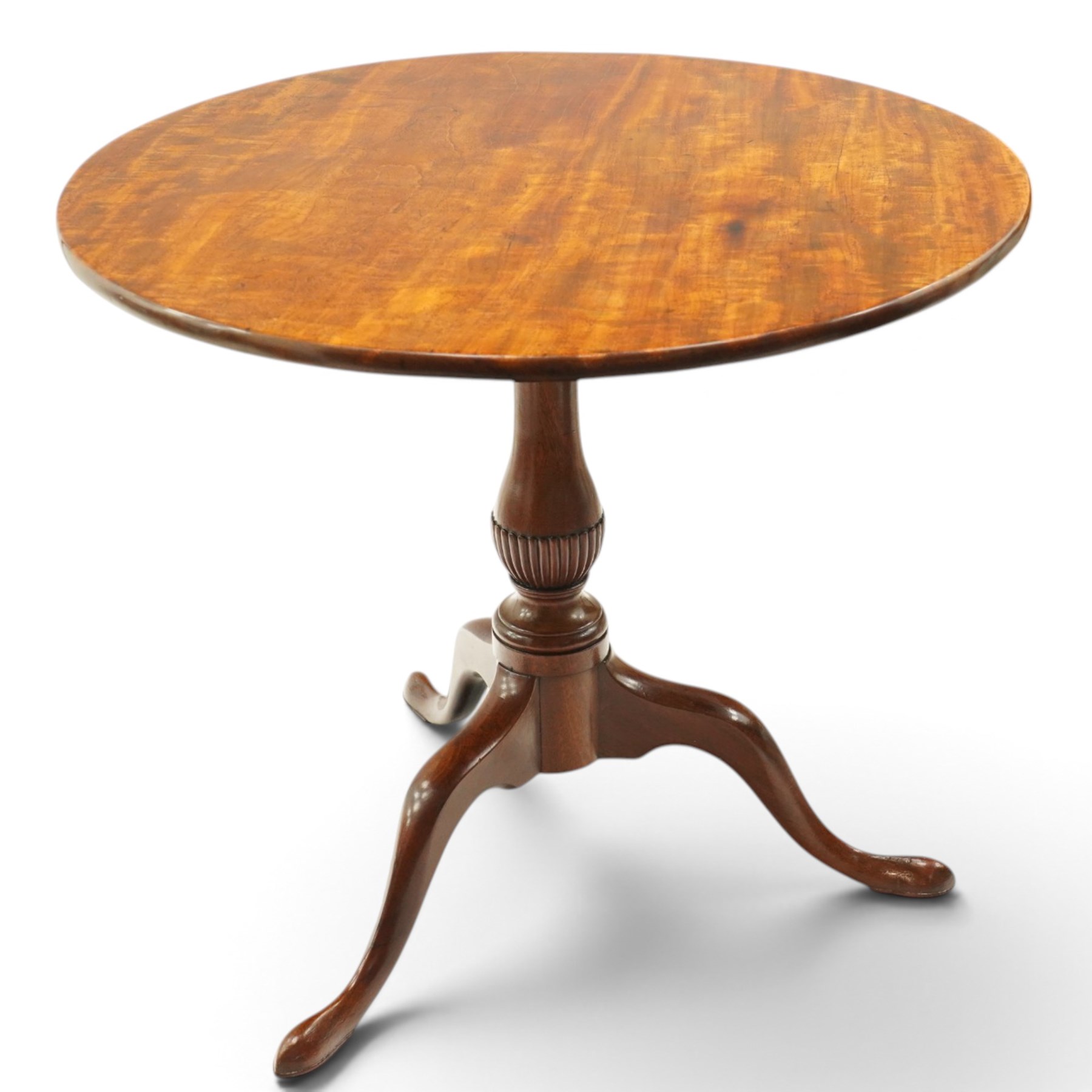 George III mahogany tilt-top tripod table, the circular figured top raised on a turned and tapering column with half-reeded lower section, over three splayed cabriole legs terminating in pad feet

Notes: several tables made by York cabinet maker John Walker for Harewood House share the same half reeded column, after the original drawing by Thomas Chippendale (c.f. The Life and Works of Thomas Chippendale, Christopher Gilbert, 1978, p.264)