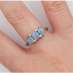 9ct gold three stone opal doublet ring, with four diamond accents set between
