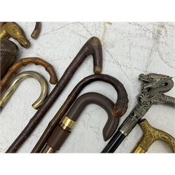 Collection of walking sticks, to include a a modern hidden umbrella stick, wooden pommel example inscribed 1910, two collapsible examples and a thumb stick, etc