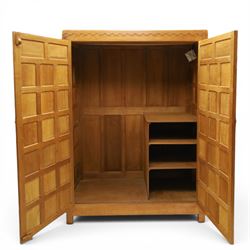 Mouseman - early-to-mid-20th century panelled and adzed double wardrobe, the arcade carved cresting rail over two panelled doors, with wrought metal hinges and latch, deep relief carved mouse signature, the interior fitted with hanging rail, by the workshop of Robert Thompson of Kilburn