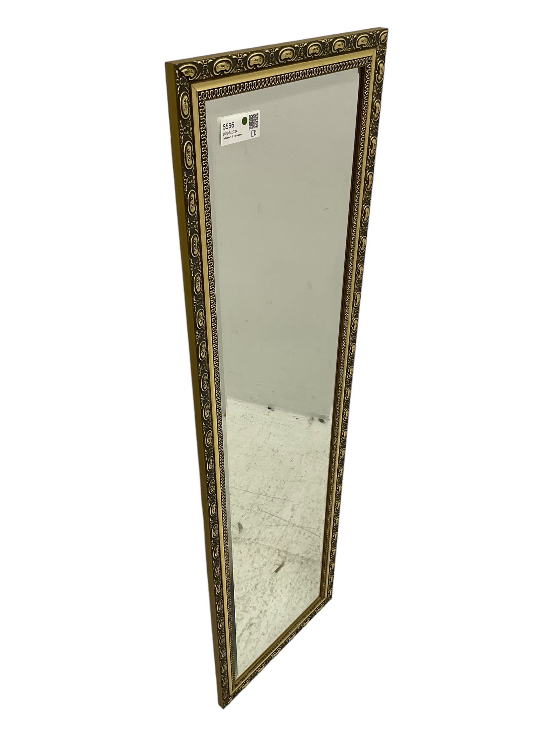 Gilt framed wall mirror, rectangular bevelled mirror plate enclosed by gilt-edged border with continuous wave pattern, outer border with oval medallions and foliate designs