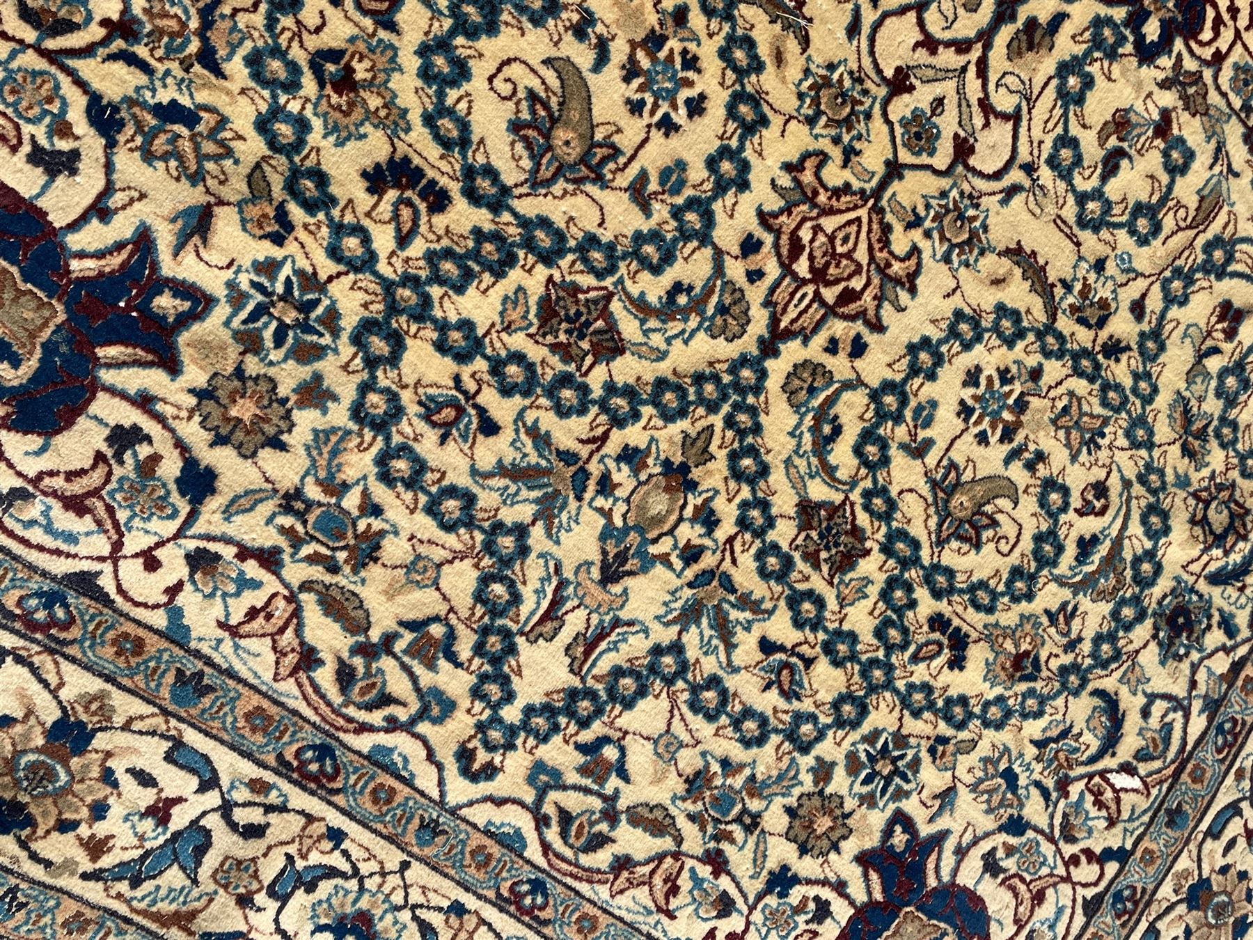 Persian Kashan ivory ground rug, wool with silk inlay, central floral rosette medallion surrounded by trailing flower heads and interlacing leafy branches, the repeating scrolling border decorated with palmettes, within guard stripes