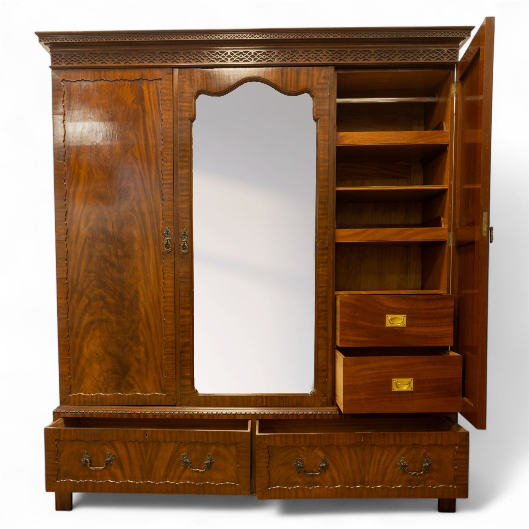 Waring and Gillow - Edwardian style figured mahogany three-section figured wardrobe, moulded and blind fretwork cornice, above three panelled doors, central door with bevelled mirror plate flanked by book-matched flame mahogany panels with moulded borders, above two long drawers with swan-neck handles, raised on bracket feet 