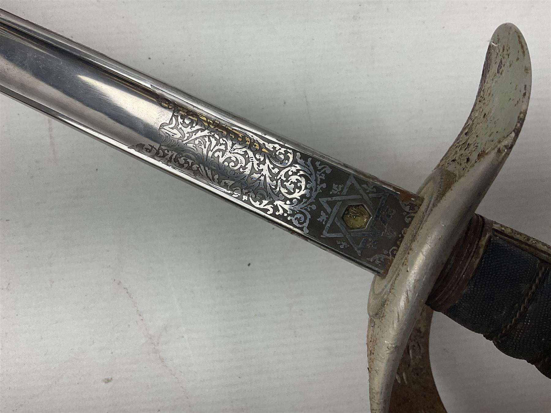 George V 1897 pattern Army Officer's sword by Henry Wilkinson Pall Mall London, the 82.5cm 'London Made' blade etched to both sides with Royal Crests and cyphers etc, pierced half-basket hilt with wire-bound fish skin grip and remains of leather knot strap; in leather covered field service scabbard L101cm overall; and two 14th Prince of Wales Own swagger sticks (3)