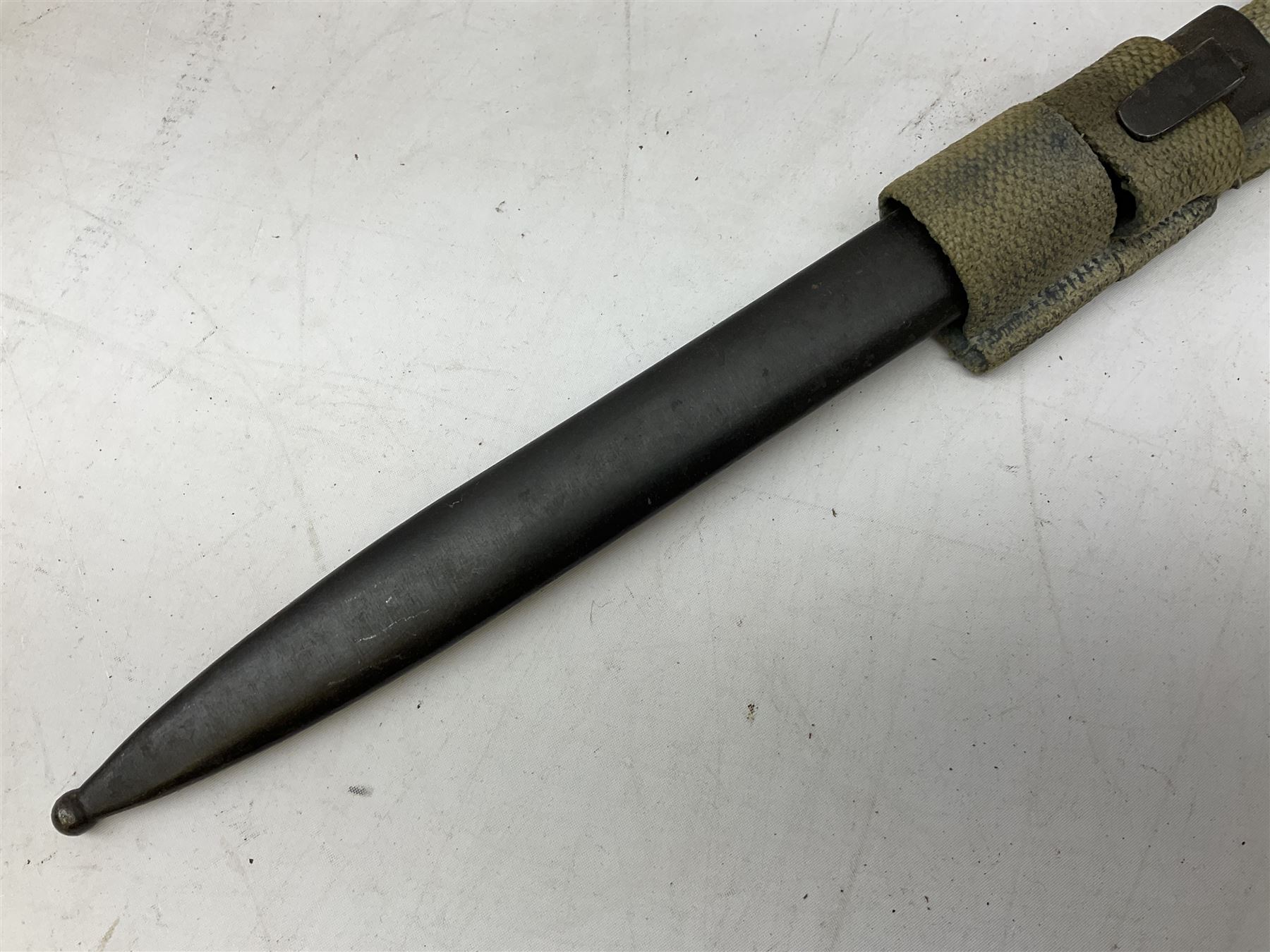 Italian Model 1891 Carcano knife bayonet with 30cm fullered steel blade, the cross-piece stamped VL1110; in steel scabbard with webbing frog L43cm overall; and another Italian fighting knife/bayonet in brass bound leather scabbard (2)