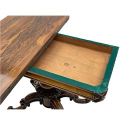 Victorian figured rosewood card table, fold-over swivel top with circular baize lining, moulded frieze with stylised flower head carving to corners, turned column with egg and dart decoration, on quadruple splayed c-scroll carved supports, with brass castors