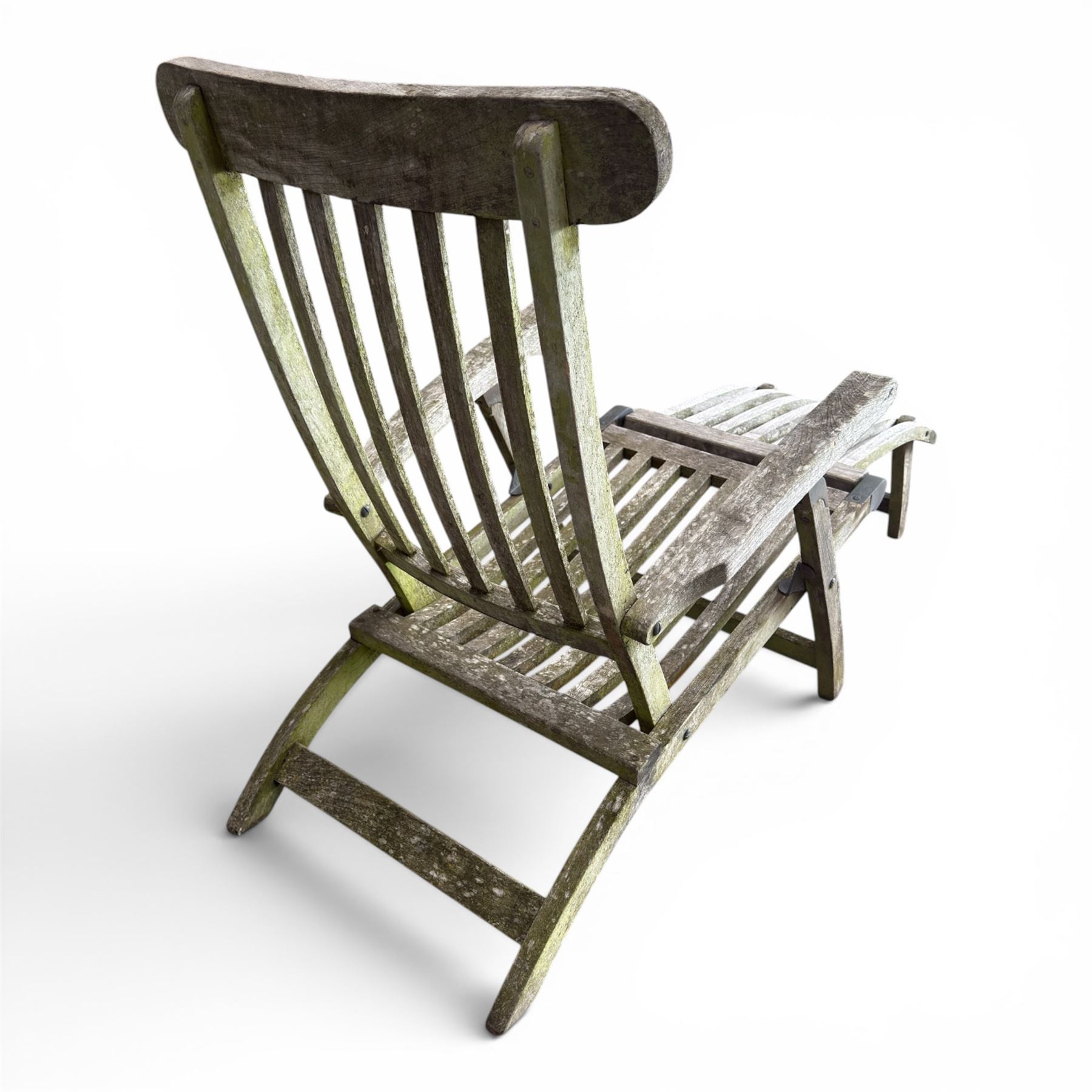 Pair of teak reclining garden steamer armchairs, each with an adjustable slatted back, curved slatted seat and footstool