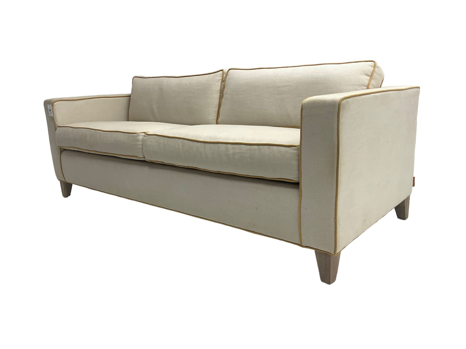 Neptune - pair three seat 'Shoreditch' sofas,  upholstered in cream fabric with yellow stringing