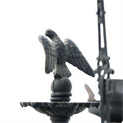 Late 19th century wrought metal hanging ceiling lamp, the ornate pierced central reservoir-form body with mounted eagle, three scrolling branches fitted with three clear glass chimney shades, suspended by decorative chains from a pierced ceiling rose