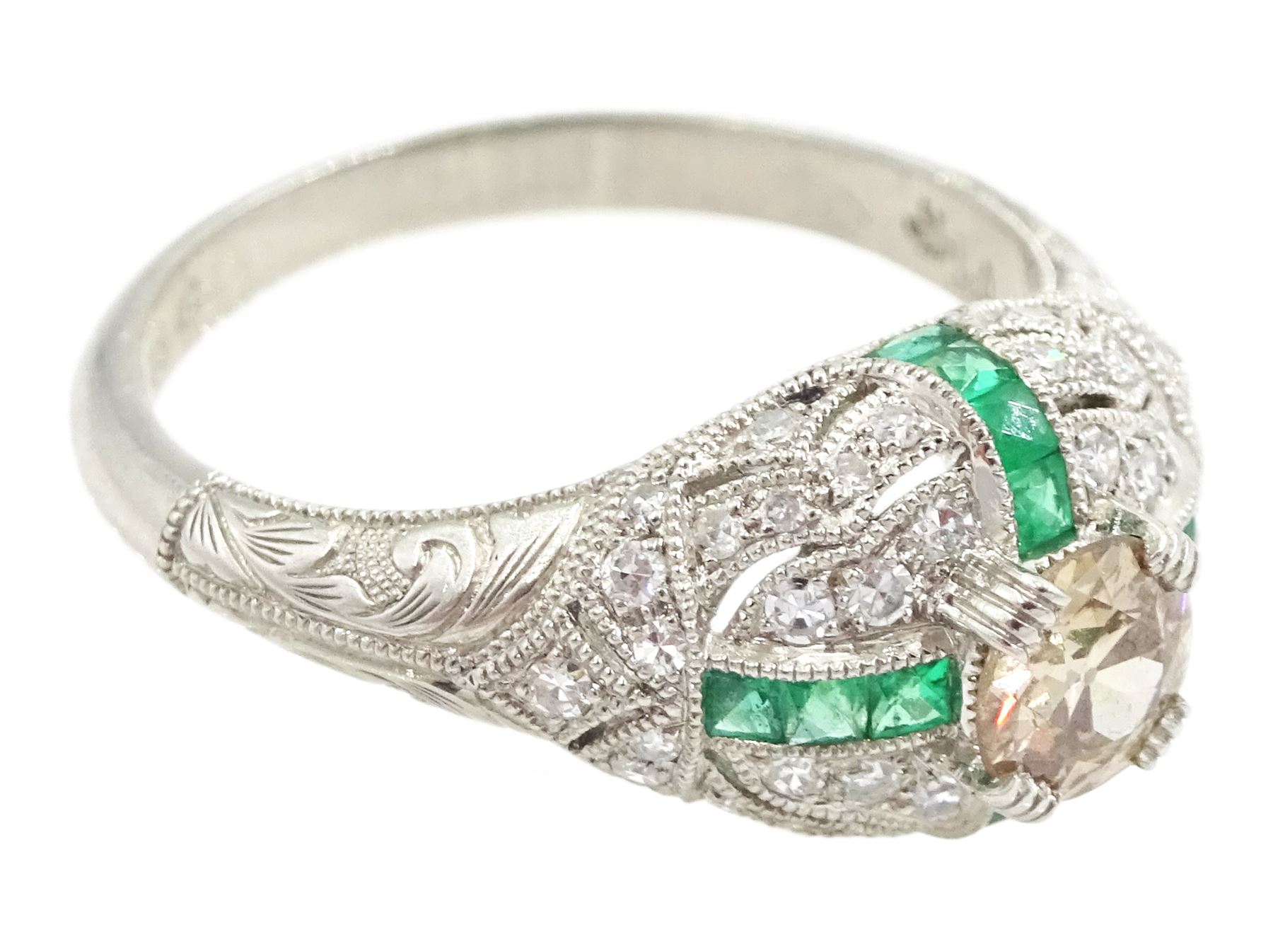 Platinum emerald and diamond ring, the principal transitional cut diamond of 0.41 carat, with milgrain set calibre cut emeralds and single cut diamonds surround and engraved foliate decoration shoulders, stamped Plat