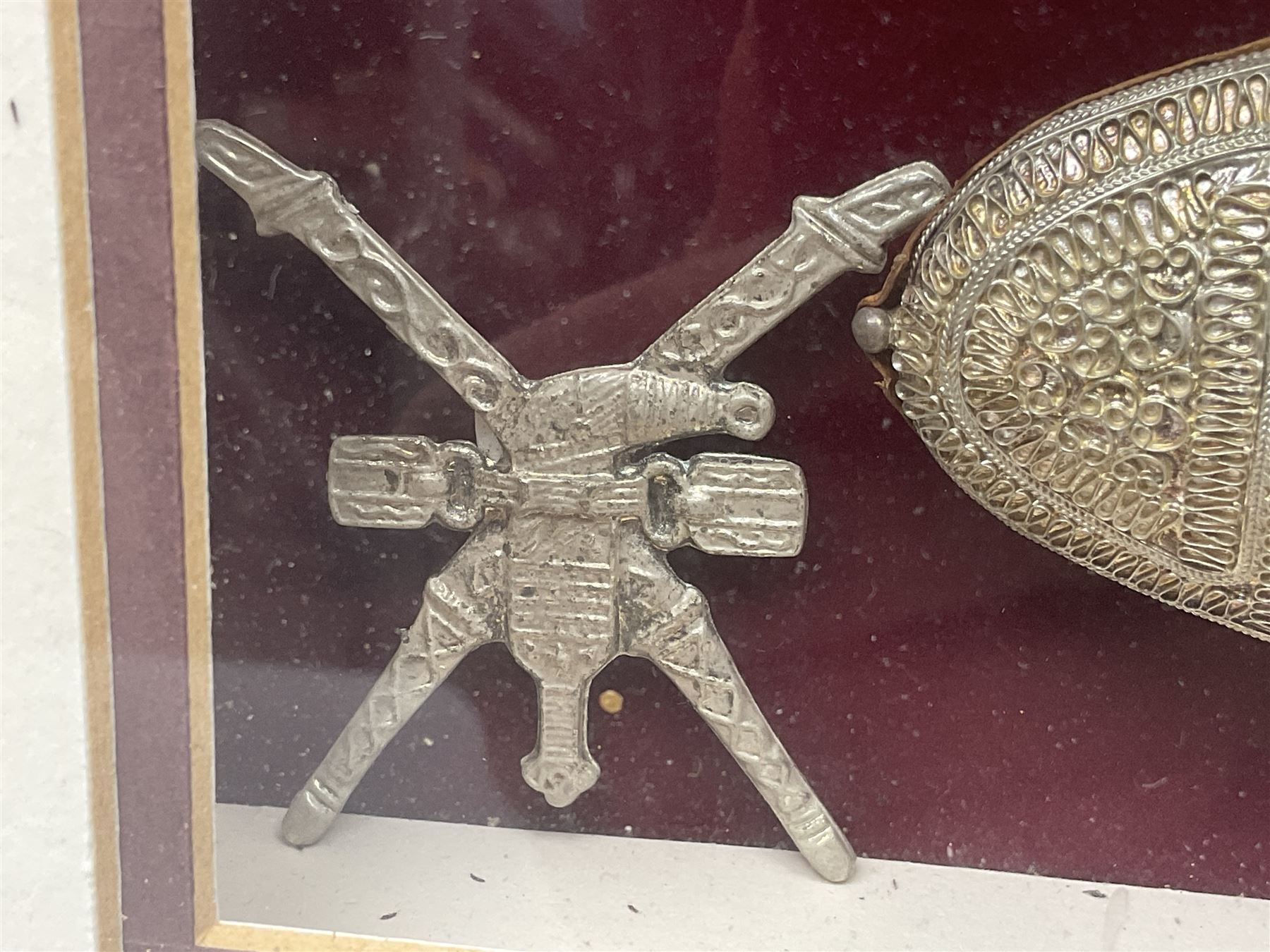 20th century silver Khanjar dagger from Oman, heavily decorated with filigree throughout, dome shaped pommel and waisted grip, the sheath with fastening rings, with miniature curved dagger accessory, housed in red lined glazed box frame, L38cm