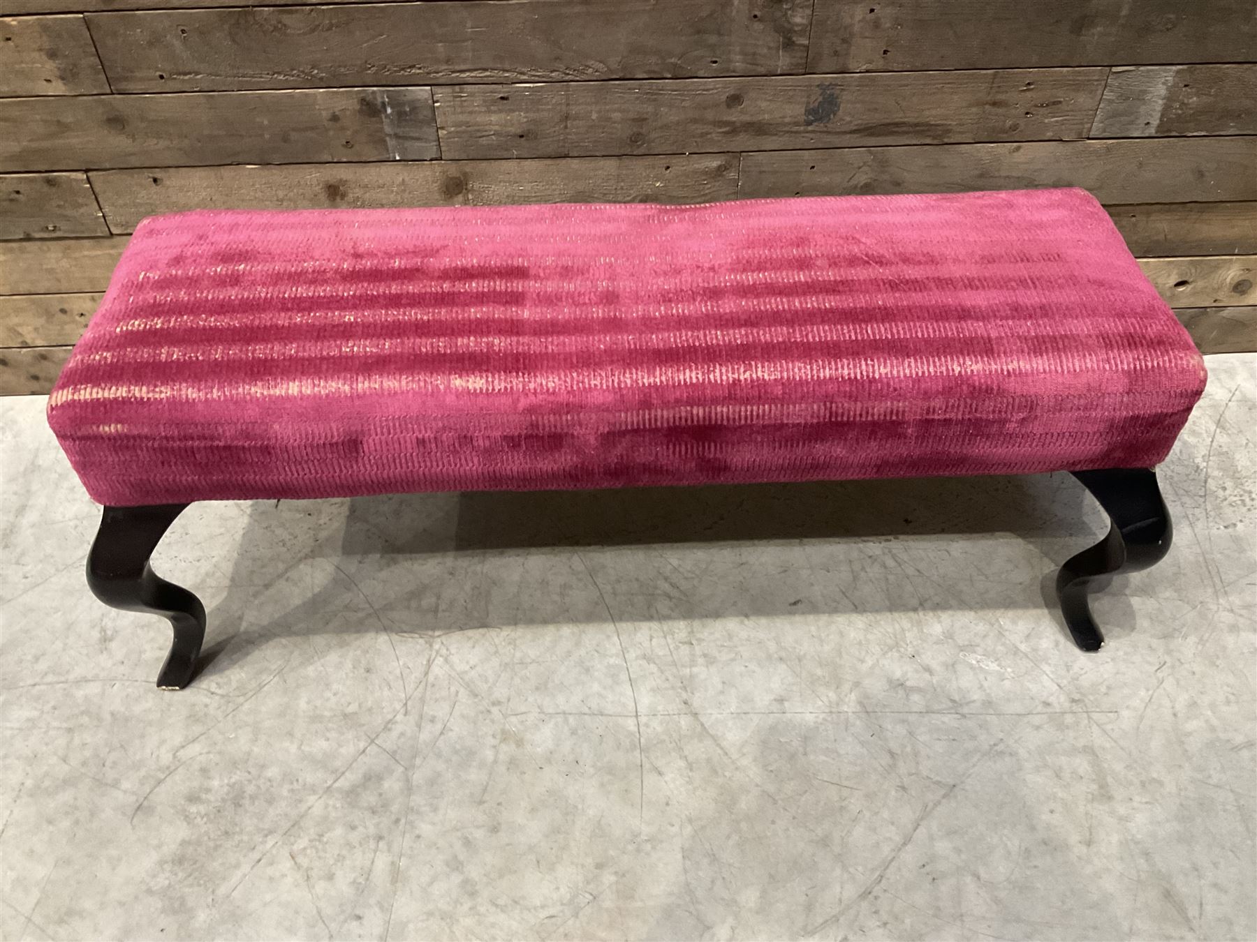 Large rectangular footstool upholstered in a maroon fabric with cabriole supports
