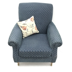 Marks and Spencers Howard style armchair upholstered in blue fabric on turned front supports with brass castors, W89cm