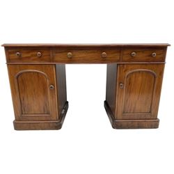 Victorian mahogany twin pedestal desk, rectangular top with green leather inset writing surface and moulded edge, fitted with three frieze drawers, the pedestals fitted with three drawers and three sliding trays, enclosed by arched fielded panel cupboard doors, on skirted base