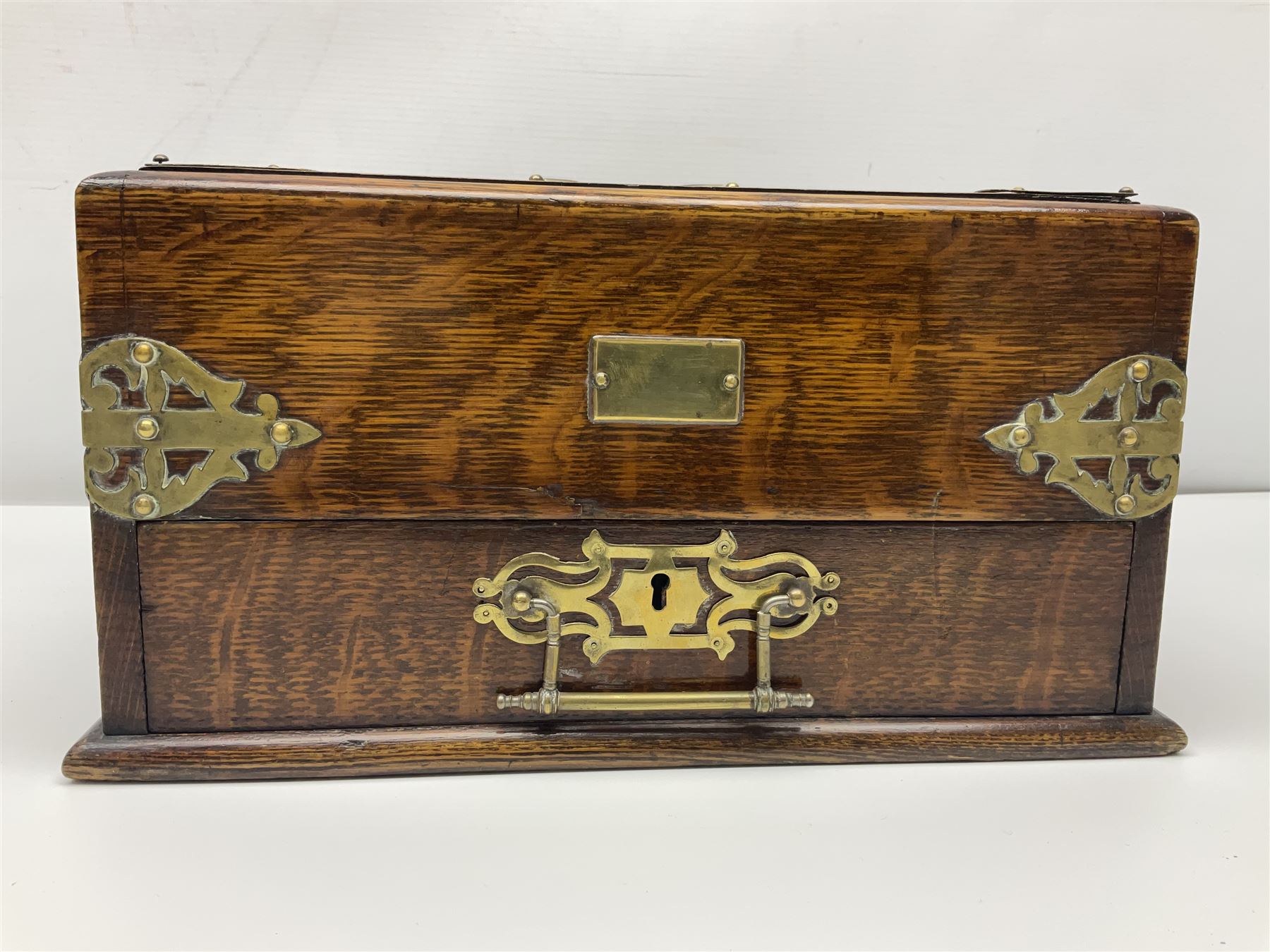 Brass mounted oak humidor, the slide action top opening to a base drawer, cedar lined with central compartment and striker, the drawer stamped Rd 107198, H17cm, D18cm