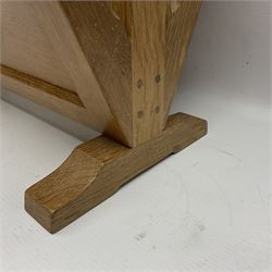 Mouseman - oak magazine rack, the top rail pierced with handle and carved with mouse signature, octagonal supports with two panelled and splayed sides, on sledge feet, by the workshop of Robert Thompson, Kilburn 