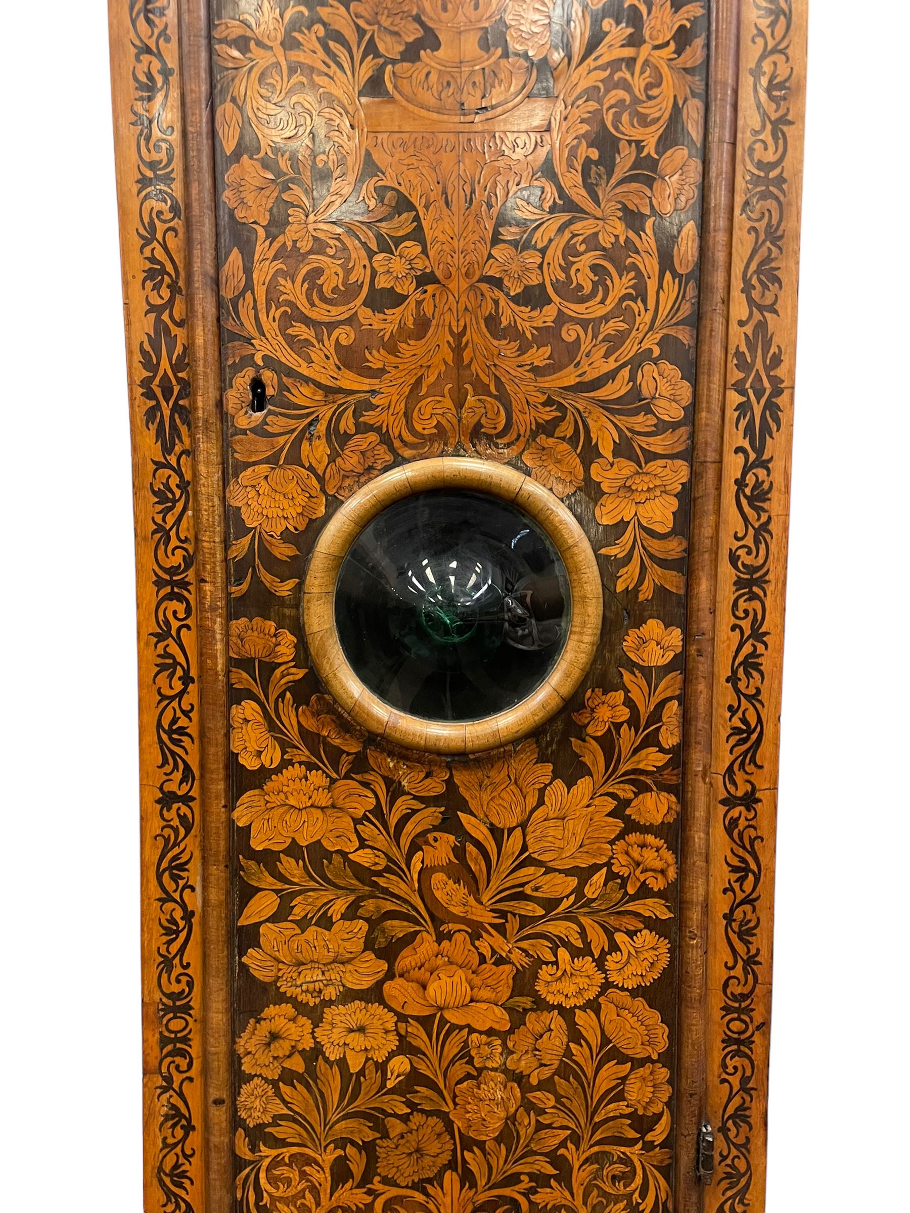 William & Mary floral marquetry 8-day longcase clock c 1700, later mid-18th century four pillar rack striking movement with a square brass dial and subsidiary seconds dial, ringed winding holes and calendar aperture to the matted dial centre, with London cherub head cast spandrels and (later) fretted steel hands, silvered Roman numeral chapter ring with stylised fleur di Lis half hour makers, narrow Arabic five-minutes, minute track and inner quarter hour track, signed Thomas Horlock, Hammersmith, 
case with box upstand to the domed floral marquetry decorated caddy with three brass flame finials, above a moulded cornice and fretwork frieze,  inlaid hood door with attached barley twist pillars to the front above an inlaid convex moulding, full length D moulded trunk door with a circular lenticle inlaid with floral and foliage panels inhabited with birds, on a conforming marquetry plinth with applied double skirting. Thomas Horlock is recorded as a Whitesmith & Clockmaker of Hammersmith, Middlesex.
A copy of Thomas Horlock's will dated the 15th June 1757 is held at The National  Archives Kew.