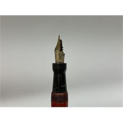 Vintage Swan Mabie Todd lever fill fountain pen in coral red, the nib a/f marked 14K, together with two further vintage Swan Mabie Todd fountain pens, the first example with lever fill, the other leverless, each with black body, one with nib marked 14ct, (3) 