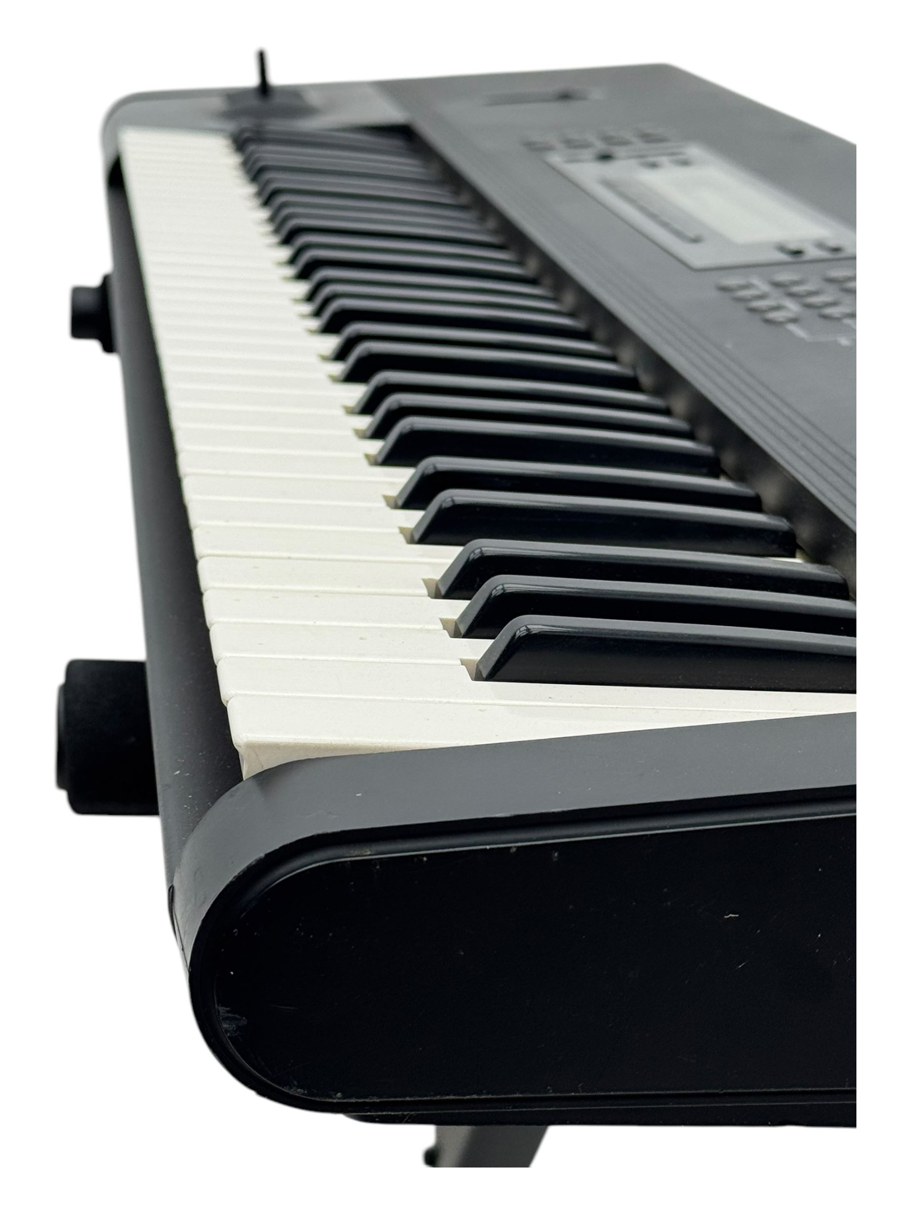 Korg M1 keyboard synthesiser, 61 velocity-sensitive keys with integrated multi-effects and eight-track sequencer, mounted on an adjustable black tubular X-frame stand with rubber end caps