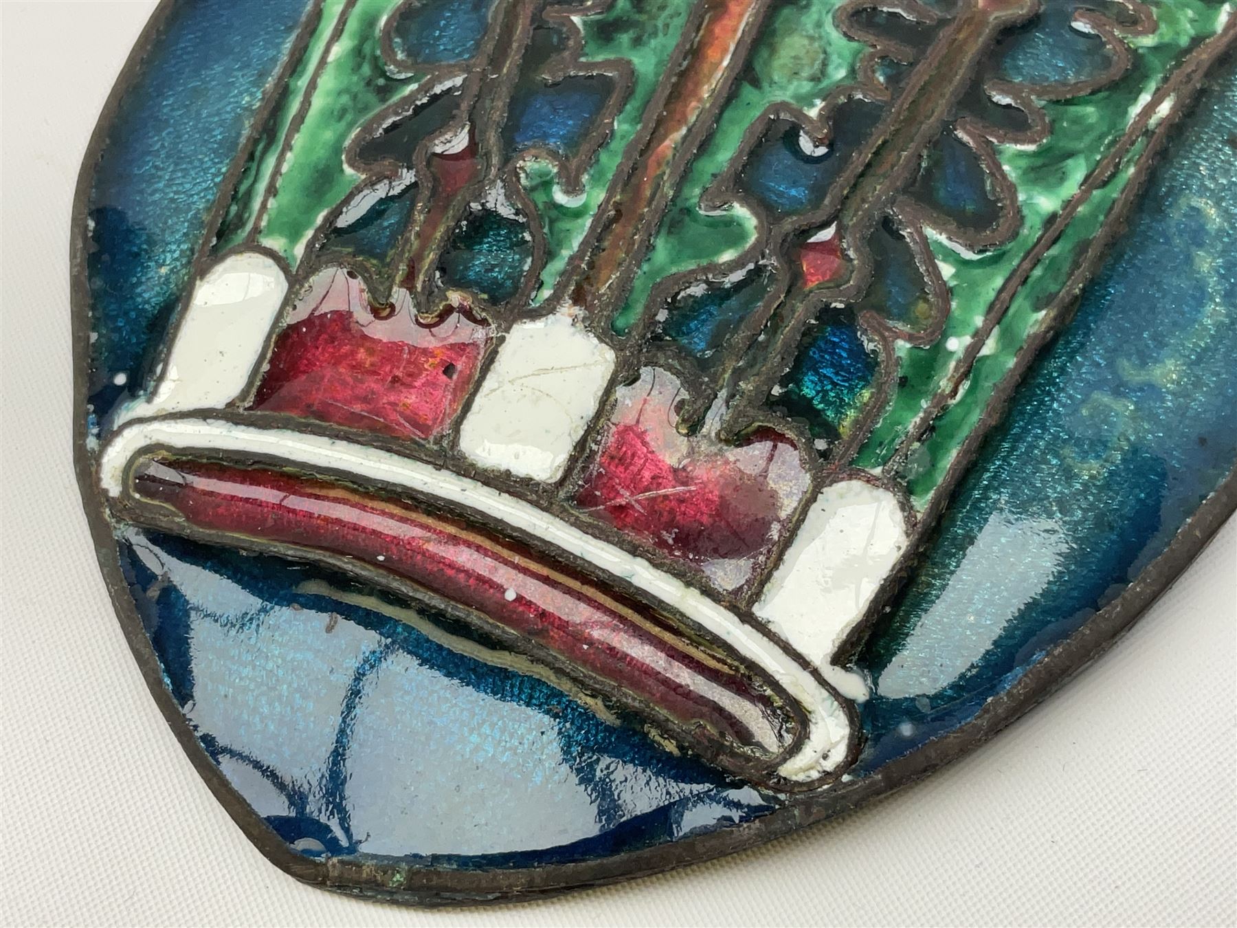 Henry George Murphy (1884-1939), Arts & Crafts enamel panel, of bulbous elliptical form decorated with a stylised crown in green, red and white, upon a turquoise toned ground, H12cm W9cm