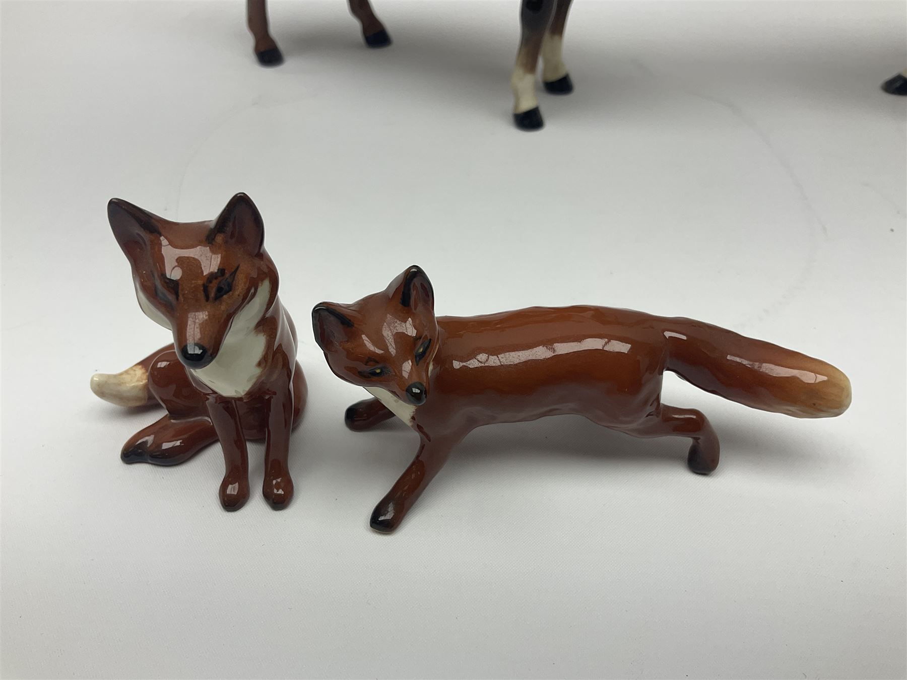Beswick hunting group, comprising huntswoman on dappled grey horse no 1730, huntsman on bay horse no 1501, two fox figures no 1440 and 1748, and four fox hounds, all with printed marks beneath (8)
