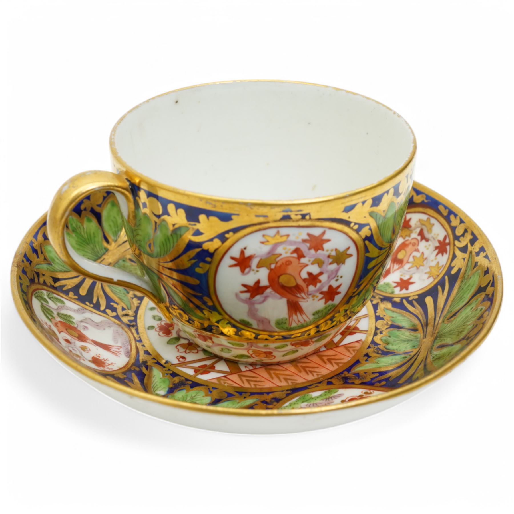 19th century teacup and saucer, possibly Coalport, decorated with panels of flowers on a cobalt blue ground with gilt decoration; together with two other teacup and saucer pairs, one with hand painted landscape decoration 
