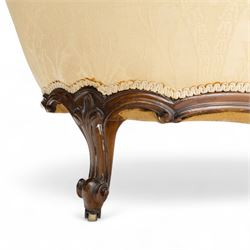 Late 19th century Victorian walnut button-back recamier, asymmetrical form, with cream damask fabric and gimp braid edging, shaped reeded apron above front and back scroll carved cabriole legs on brass castors