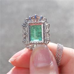 Platinum Colombian emerald and diamond pendant necklace, single octagonal cut emerald of 7.38 carat, surrounded by round cut diamonds in a fancy milgrain pierced design setting, stamped Pt 950, on a trace link chain necklace, total diamond weight 1.14 carat, with GCS certificate