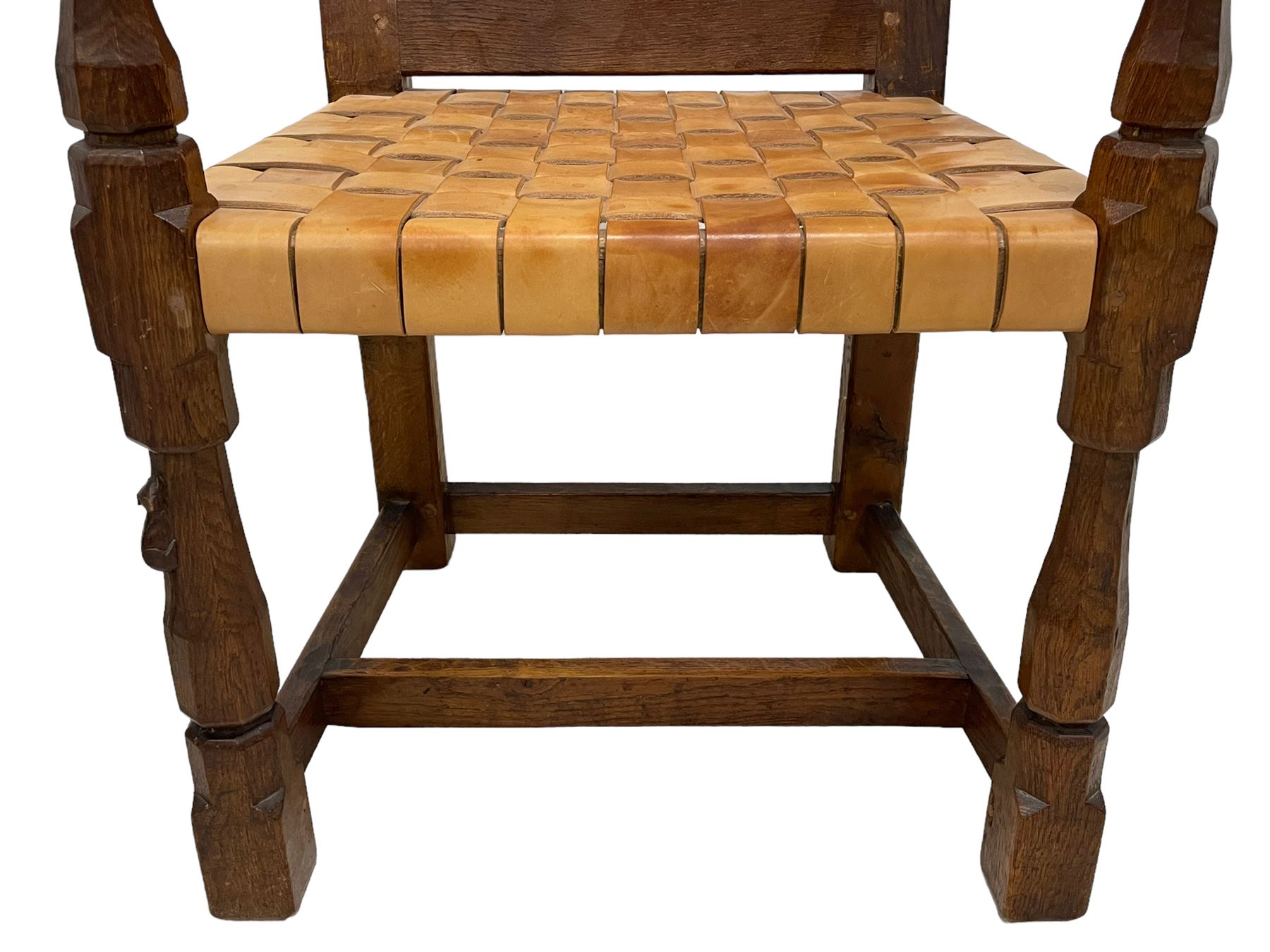 Mouseman - circa. 1930s set of six (4+2) oak dining chairs, panelled back carved with the Bagshawe family crest, the moto 'Forma Flos Fama Flatus' over an arm grasping a bugle-horn with ribbon tie and Yorkshire rose motif, adzed frame, leather lattice strap seat, on octagonal supports united by stretchers, two carvers and four side chairs, each carved with mouse signature, by Robert Thompson of Kilburn 

Provenance: Owned since manufacture by the Bagshawe family, descendants of the Staithes Group Artist Joseph Richard Bagshawe RBA (1870-1909).