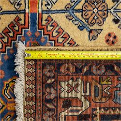 South Persian Yallameh hand-knotted rug, ivory ground, with a central stepped pole medallion design in blue and terracotta tones, surrounded by geometric tribal motifs incorporating stylised flowerheads, birds, hooked devices and angular vine work, enclosed by dark navy spandrels and a terracotta border with repeating geometric motifs, flanked by narrow patterned guard stripes, with cotton fringes