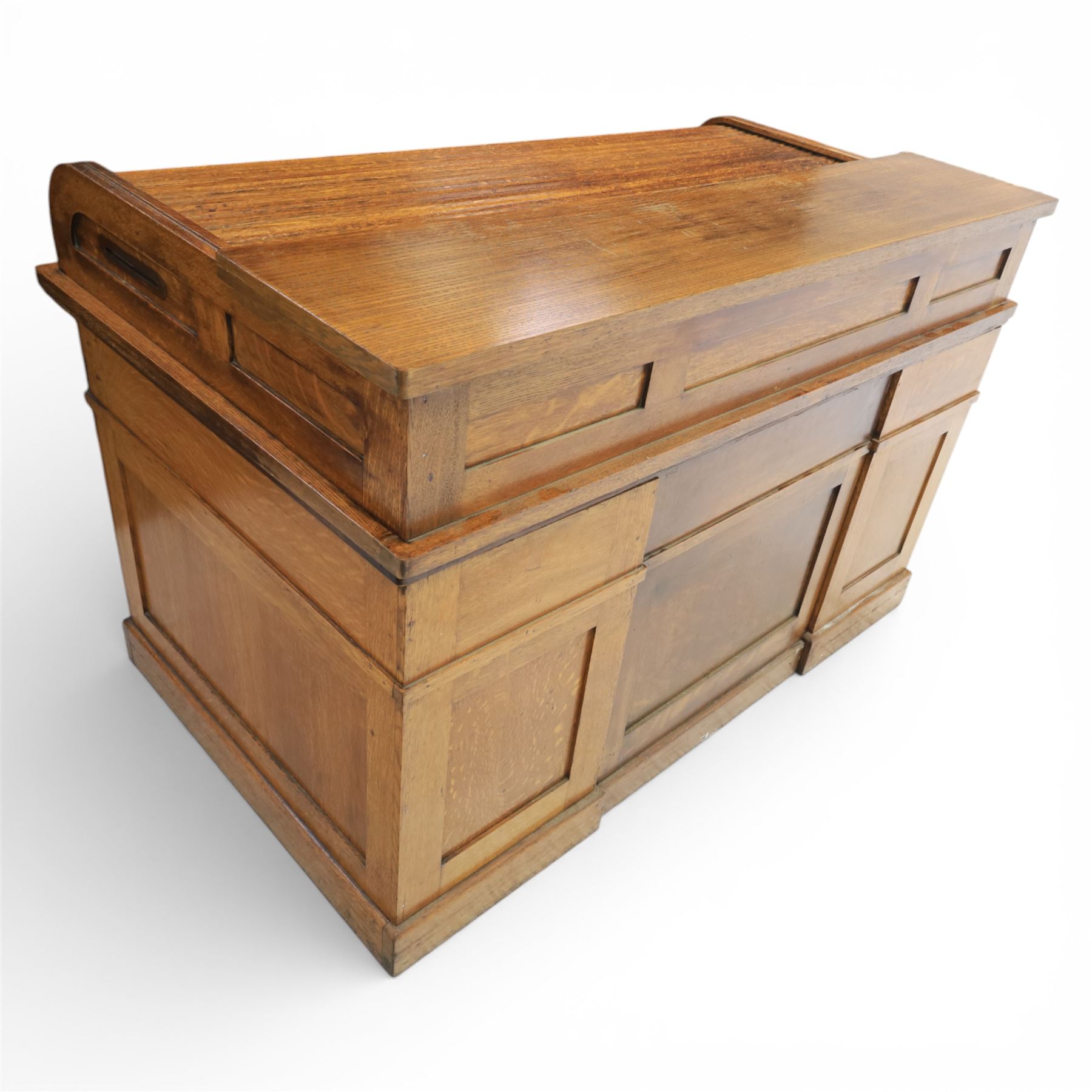 Globe Wernicke - Oak roll top desk, fitted with nine drawers, oak tambour roll top revealing a fitted interior, with single frieze drawer, flanked by four drawers to each pedestal, on a plinth base