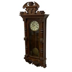 A large German wall clock c 1890 with a twin weight striking movement, striking the hours and half-hours on a gong, with a fully glazed door and carved case, two-part enamel dial with gothic hands and seconds dial, dial indistinctly signed by a Hull retailer. With weights and pendulum. 

