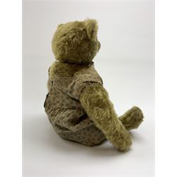 Early 20th century German Steiff teddy bear c1910 with wood wool filled humped back mohair body, swivel jointed head with black boot button eyes and horizontally stitched black nose and mouth, FF metal button to left ear, jointed elongated limbs with felt paw pads and black stitched claws H13