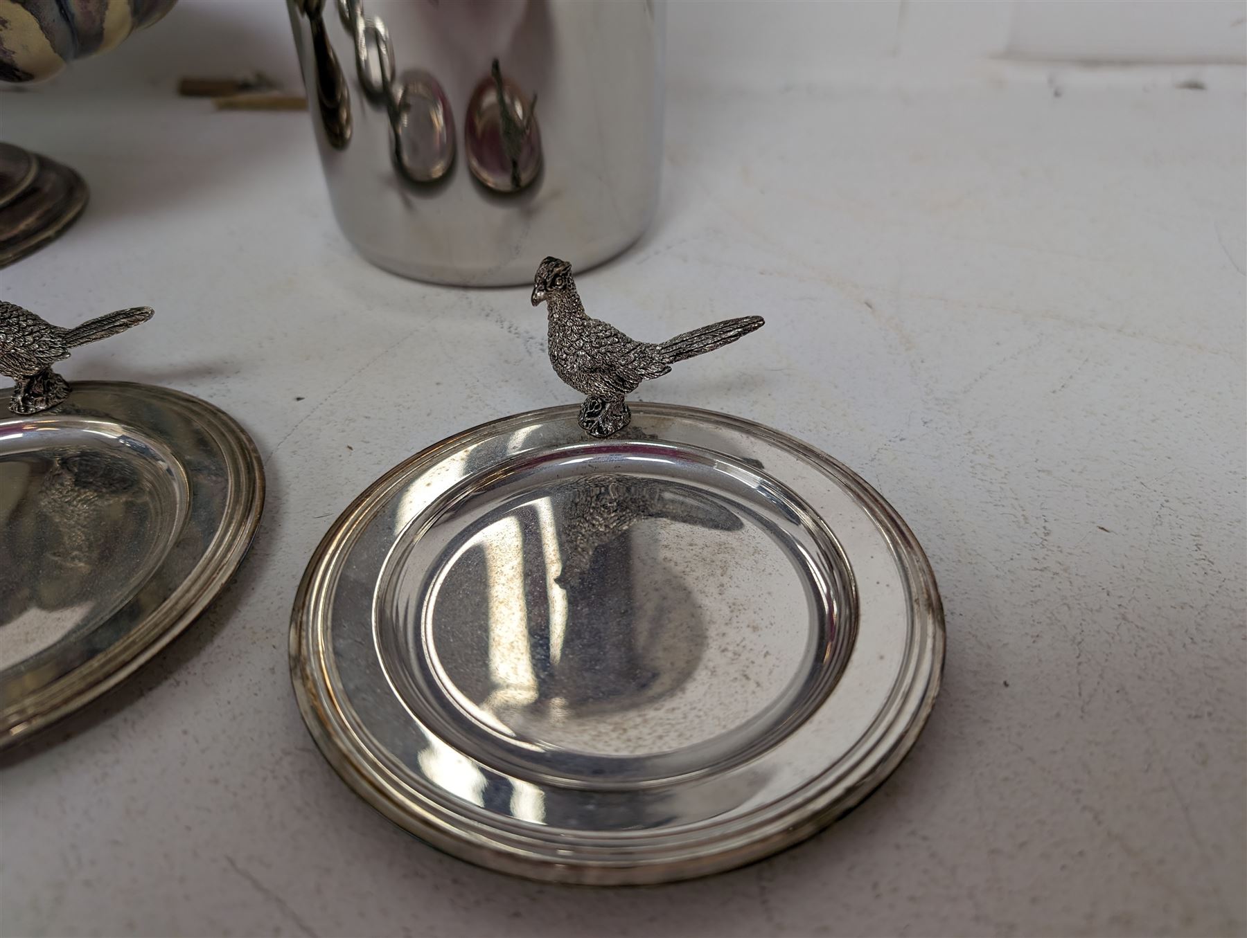 George Jensen stainless steel wine cooler, together with a silver plated pedestal dish, in the form of a clam shell and with squirrel decoration and four silver plated trinket dishes with applied pheasant decoration