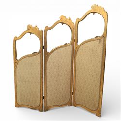 Rococo style giltwood three-panel dressing screen, each panel with shaped and scroll carved frame decorated with shell and foliate motifs, the upper sections glazed, the lower sections upholstered in patterned fabric, hinged to form a folding screen