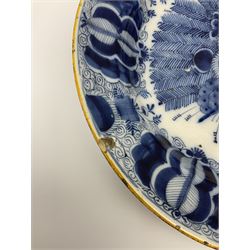 18th century Delft blue and white peacock pattern dish, painted with a fan of peacock feathers behind an urn of fruit and flowers, D34.5cm. 