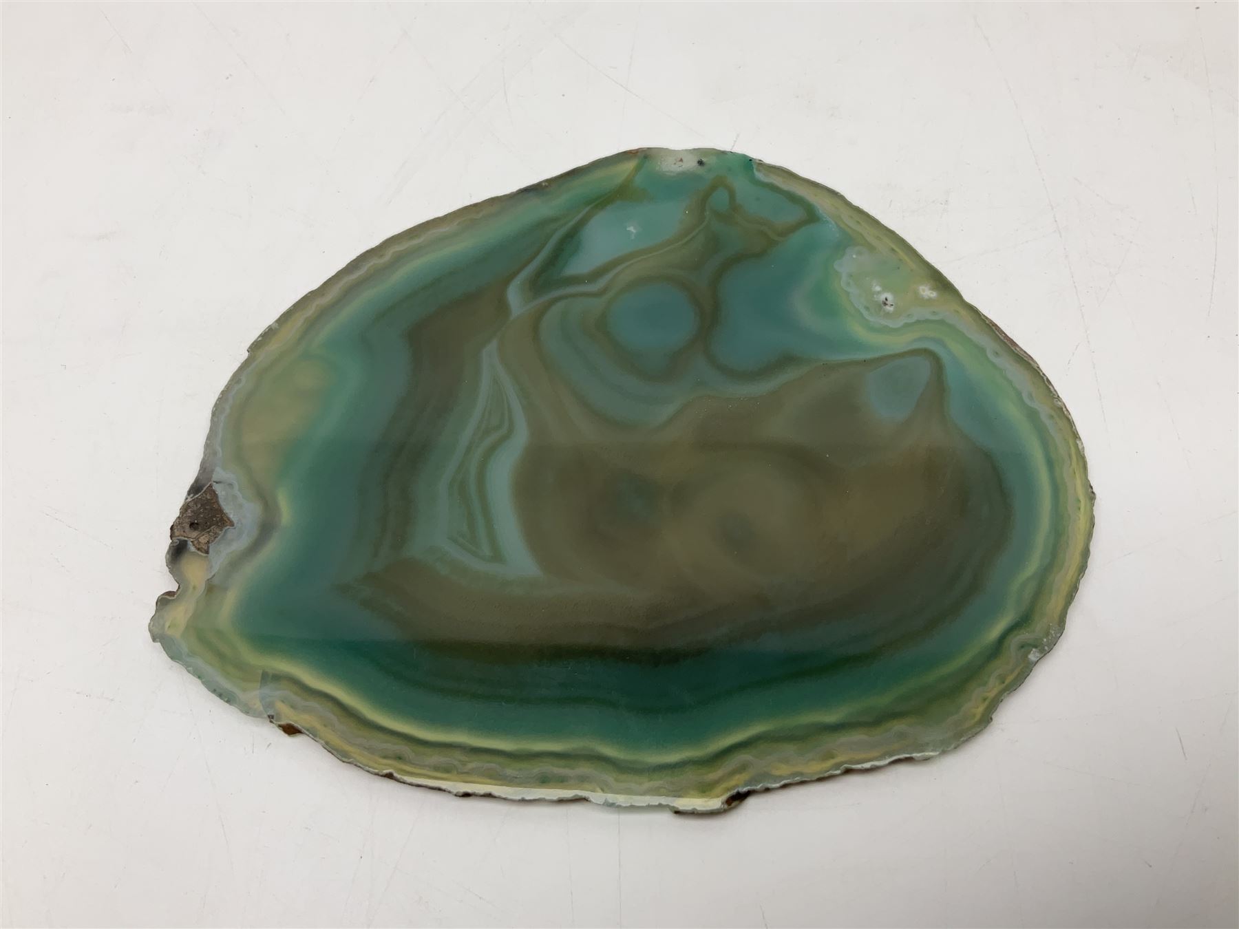 Pair of green agate slices, polished with rough edges, raised upon silvered metal stands, H23cm