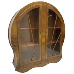 1930s Art Deco period walnut display cabinet, enclosed by two sun burst astragal glazed doors, on shaped plinth base